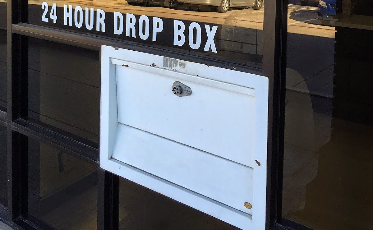 Photo from Mr Clean Cleaners&rsquo; own Google listing: the drop box set into the shop window, with 24 HOUR DROP BOX lettered on the glass above it.