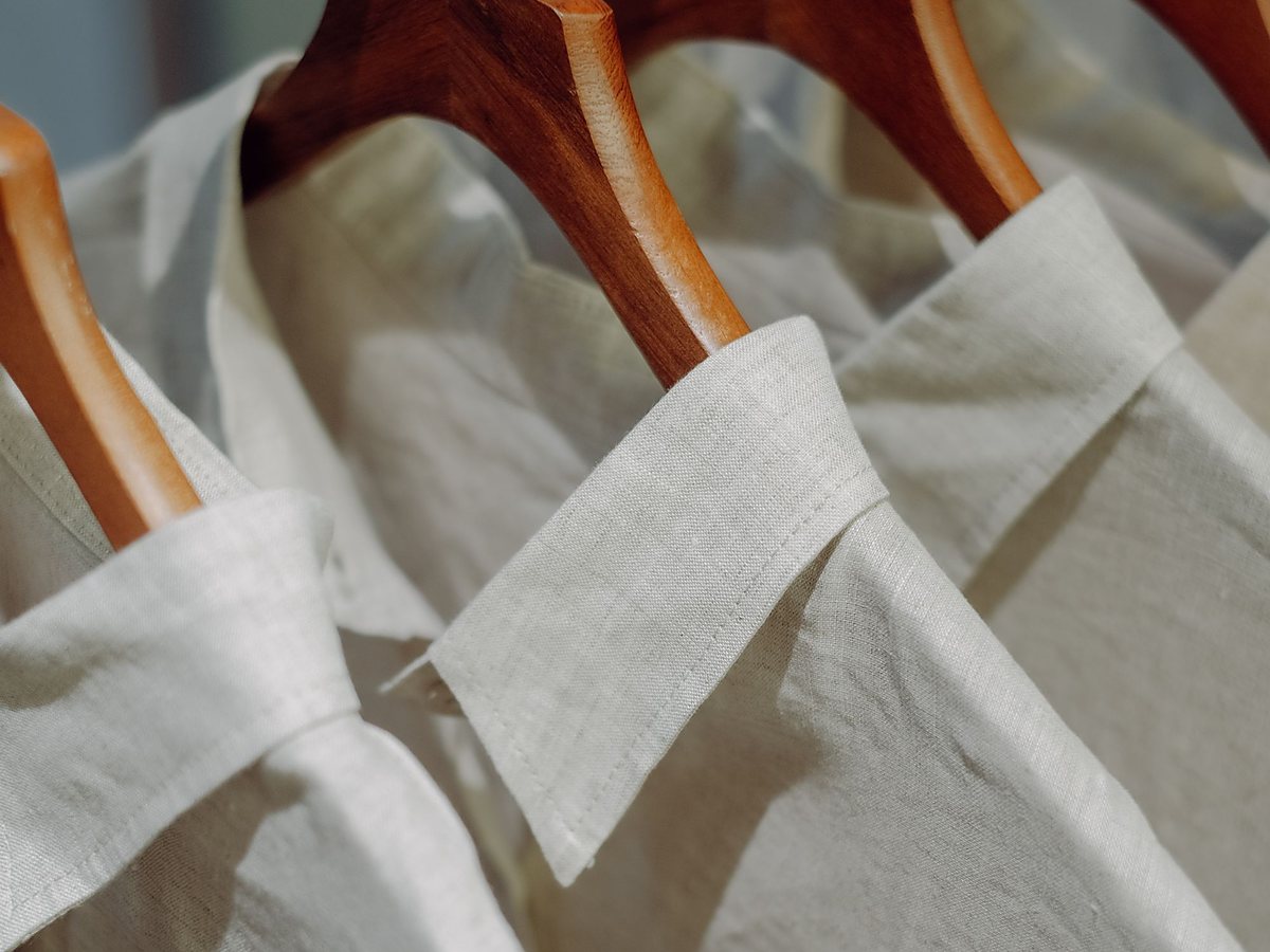 Licensed stock photograph: pressed shirt collars turned out over wooden hangers, close up.